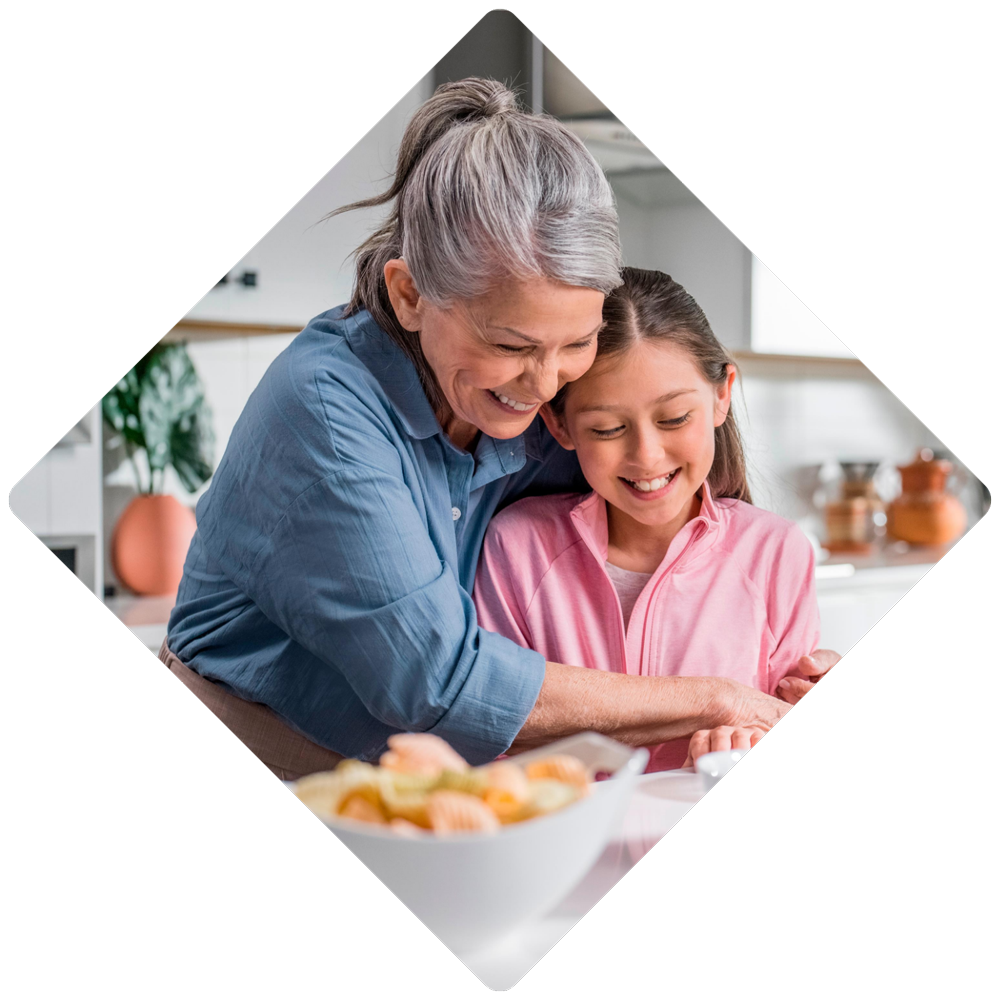 grandmother and granddaughter preparing snacks in kitchen