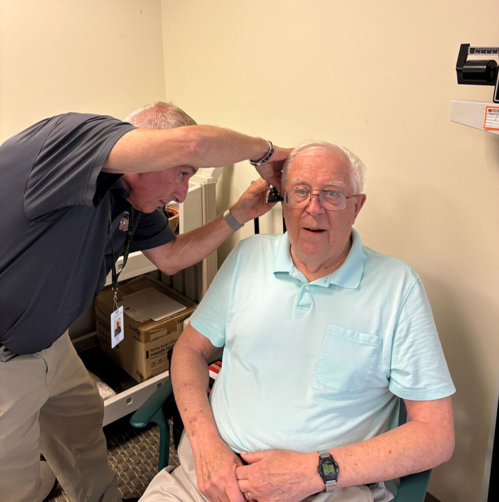 spencer miller hearing care professional looking at patient ear