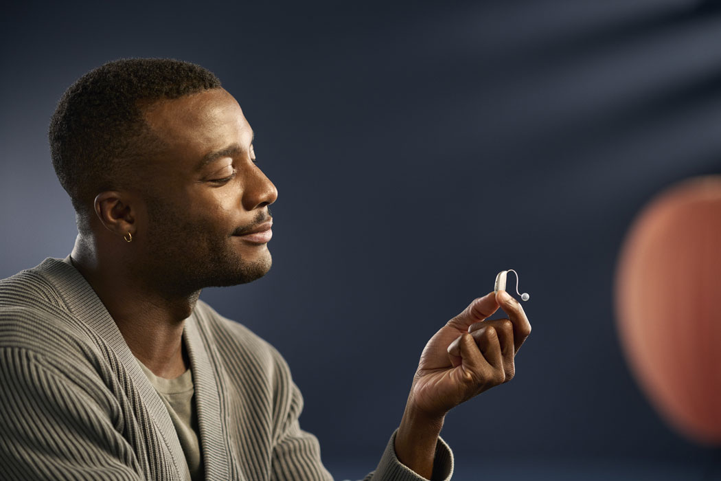 ReSound Savi lifestyle man holding silver hearing aids