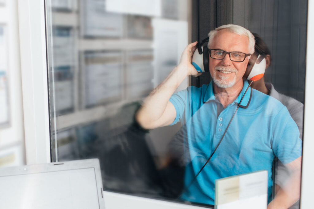 senior man hearing test sound booth