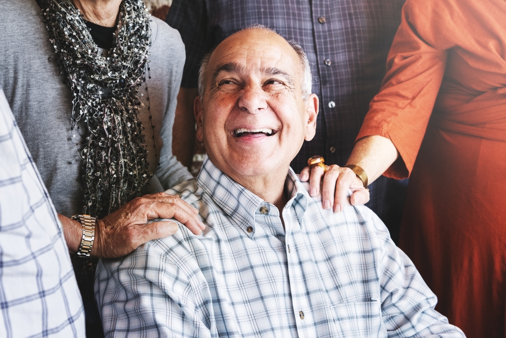 Elderly,Man,Smiling,,Surrounded,By,Group,Of,Senior,Adults,Smiling
