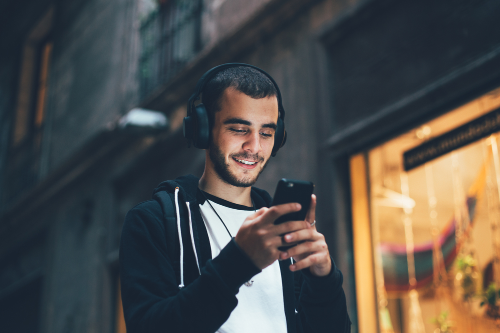 Handsome,Young,Man,In,Black,Hoodie,Wears,Big,Wireless,Music