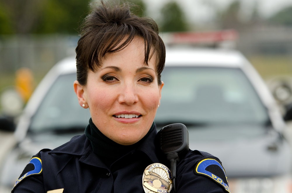 A,Female,Police,Officer,Smiling,Next,To,Her,Police,Car