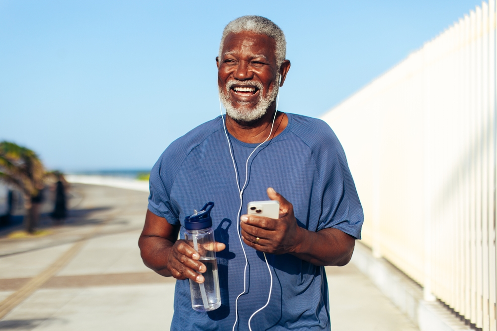 A,Happy,Senior,Black,Man,Runs,Along,A,Seaside,Promenade