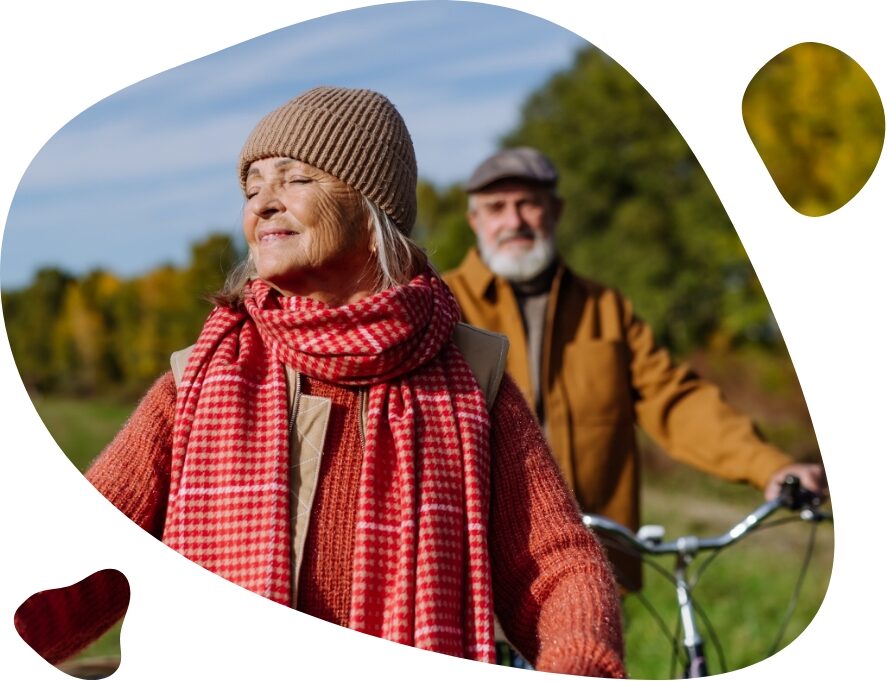 elderly couple enjoy sun walking bikes in park
