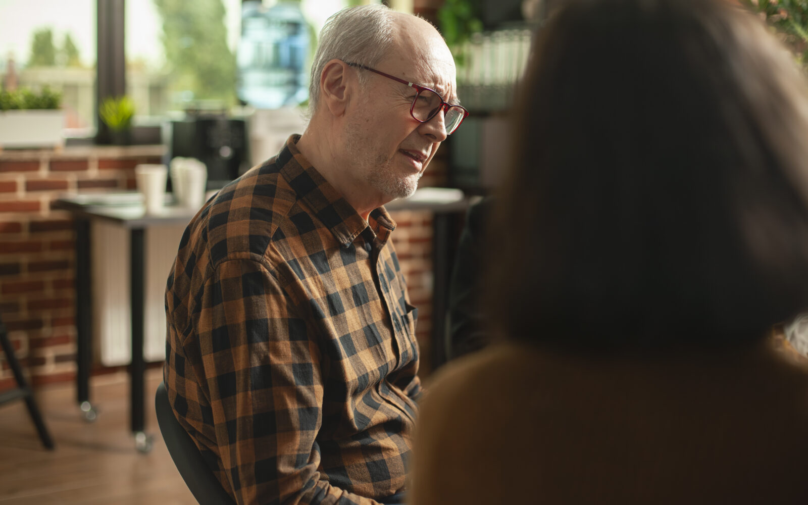 Elderly man listening in a group meeting
