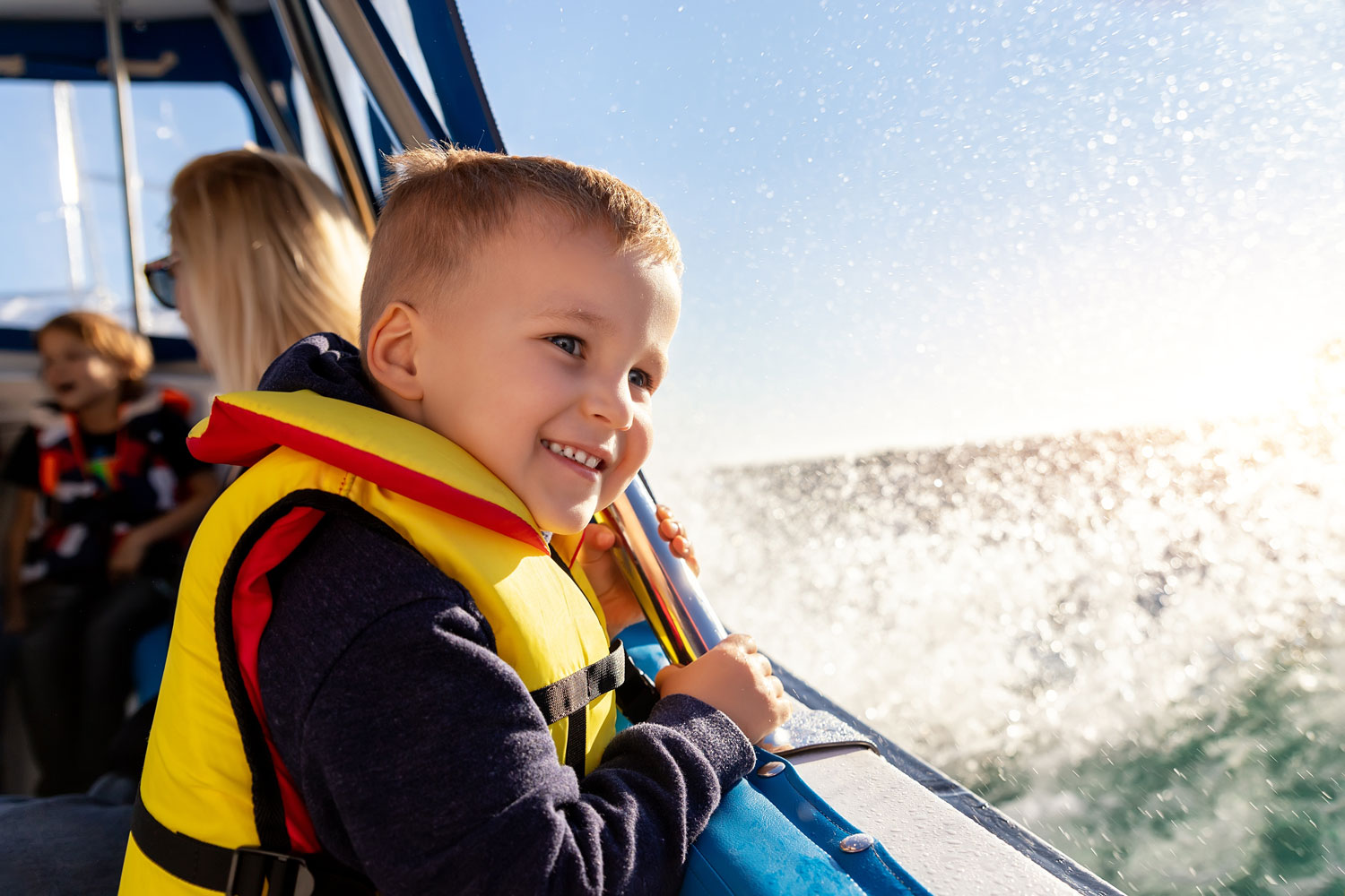 boy wear lifevest enjoy sailing on motor boat