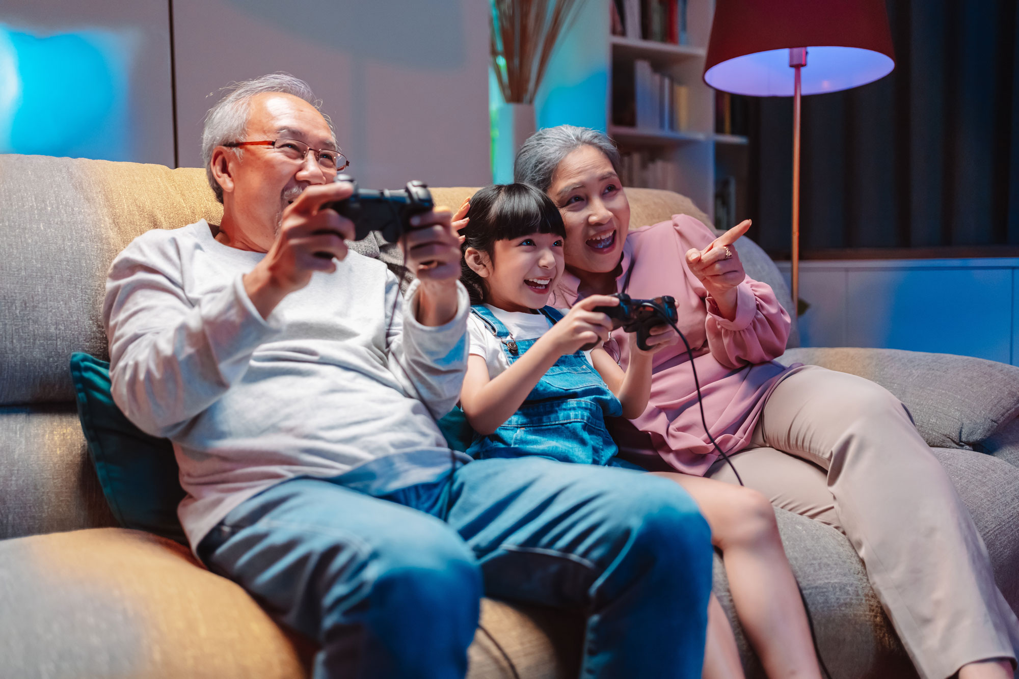 granddaughter playing video games with grandparents