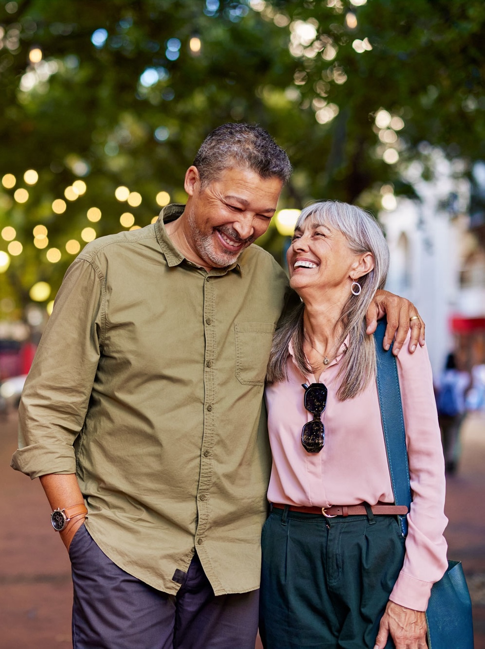 senior couple walking along street laughing portrait