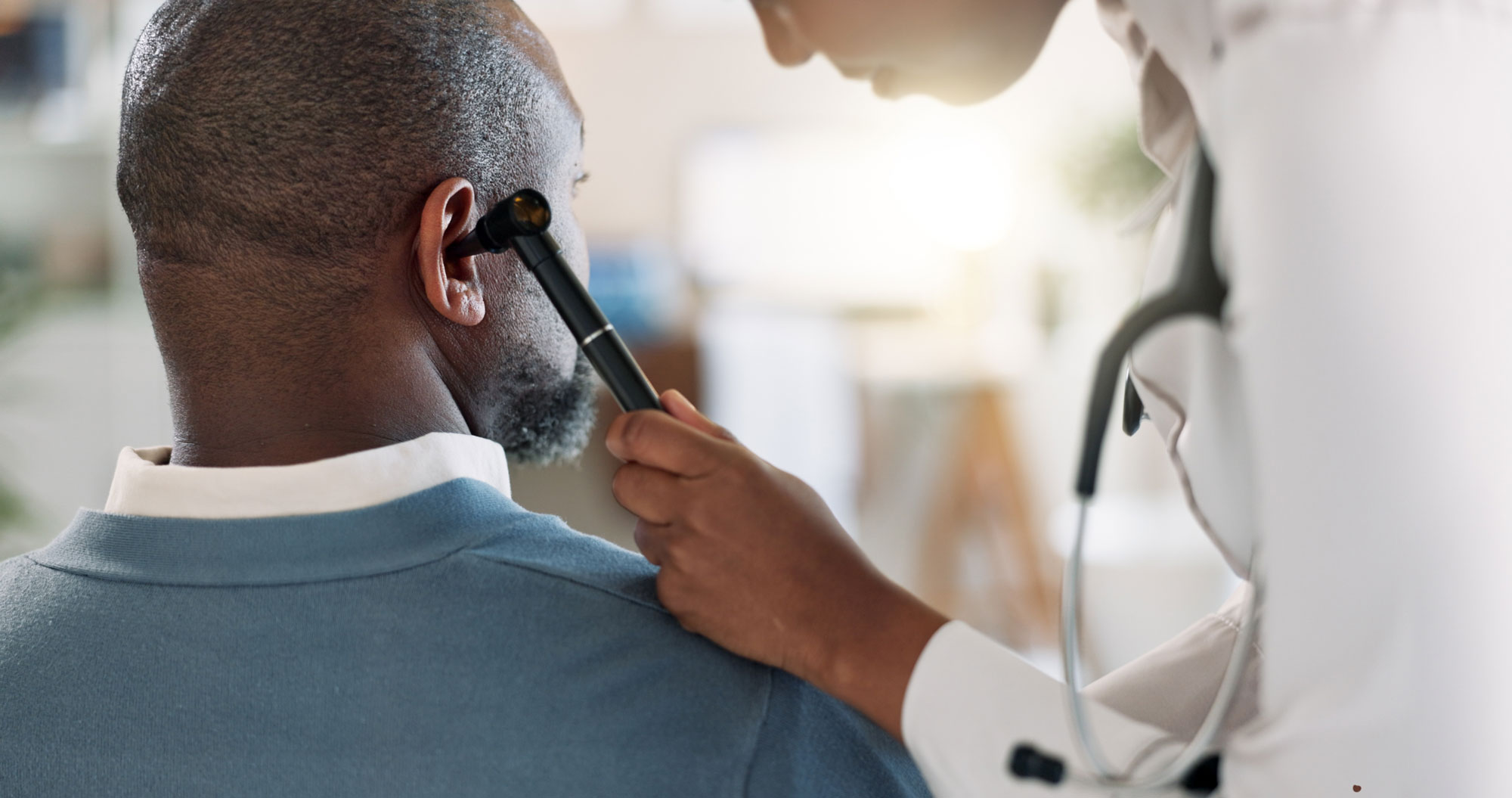 audiologist inspecting ear using otoscope on man audiologist inspecting ear using otoscope on man