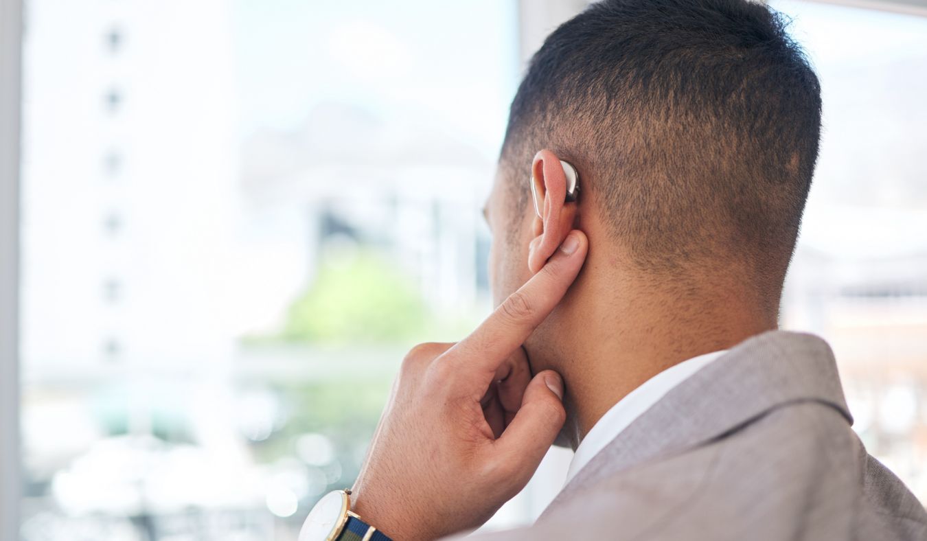 man pointing hearing aid