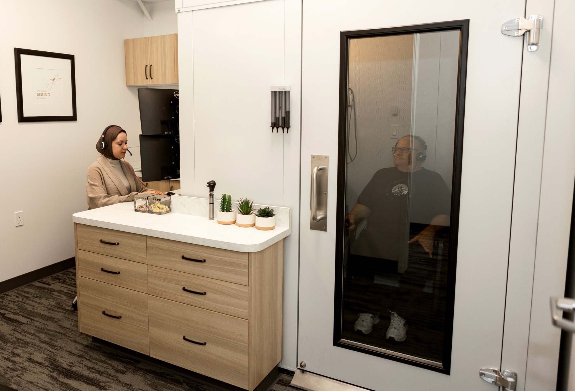 acoustic audiology Maysem Elfurjani preforming hearing test in sound booth