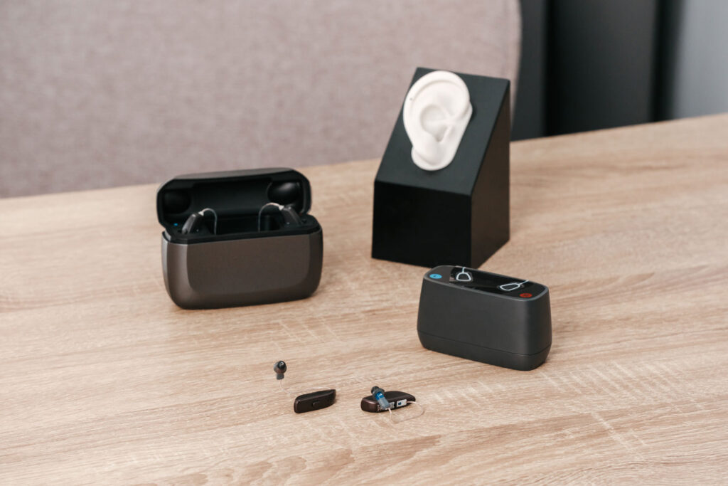 different hearing aid styles and chargers on table