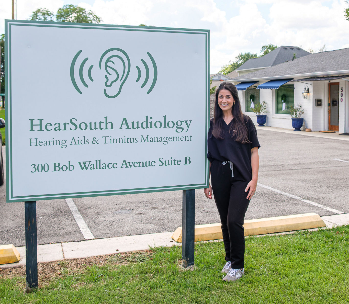 maddie next to road sign in front of clinic