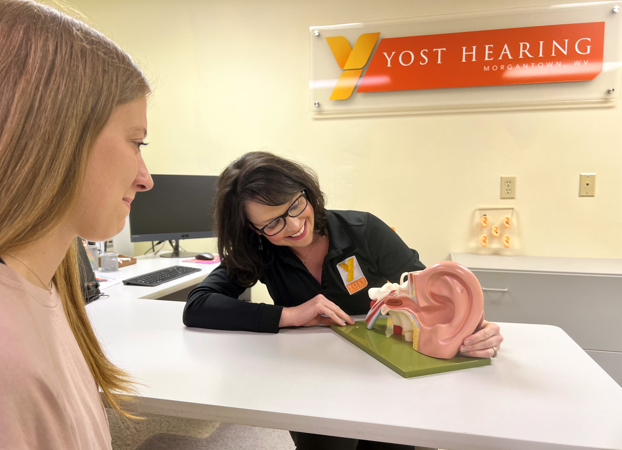 dr andi showing ear model to woman