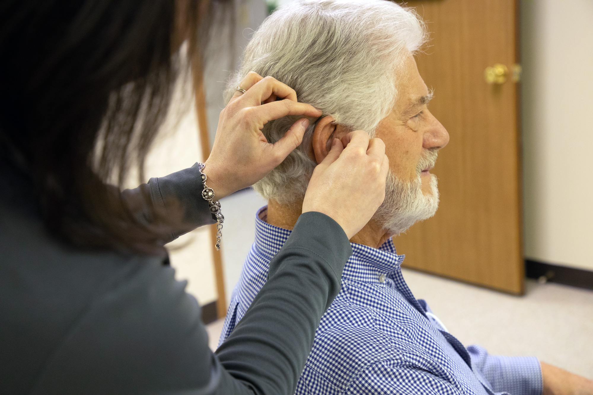 senior man trying on hearing aids