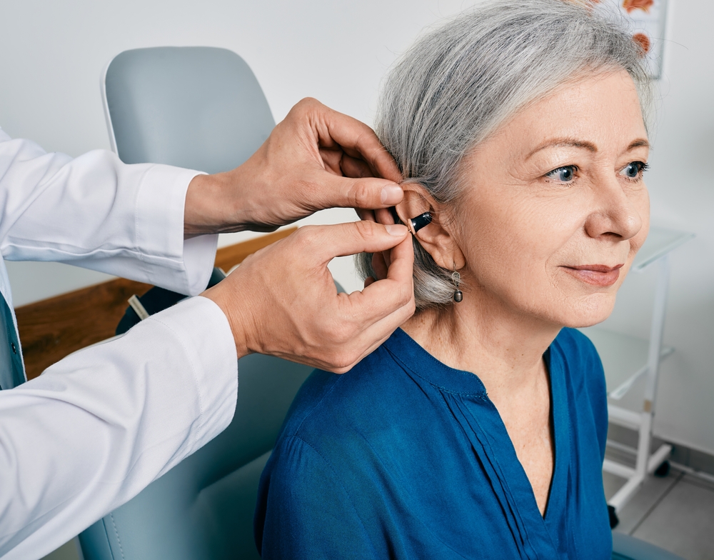 Senior,Woman,During,Installation,Hearing,Aid,Into,Her,Ear,By