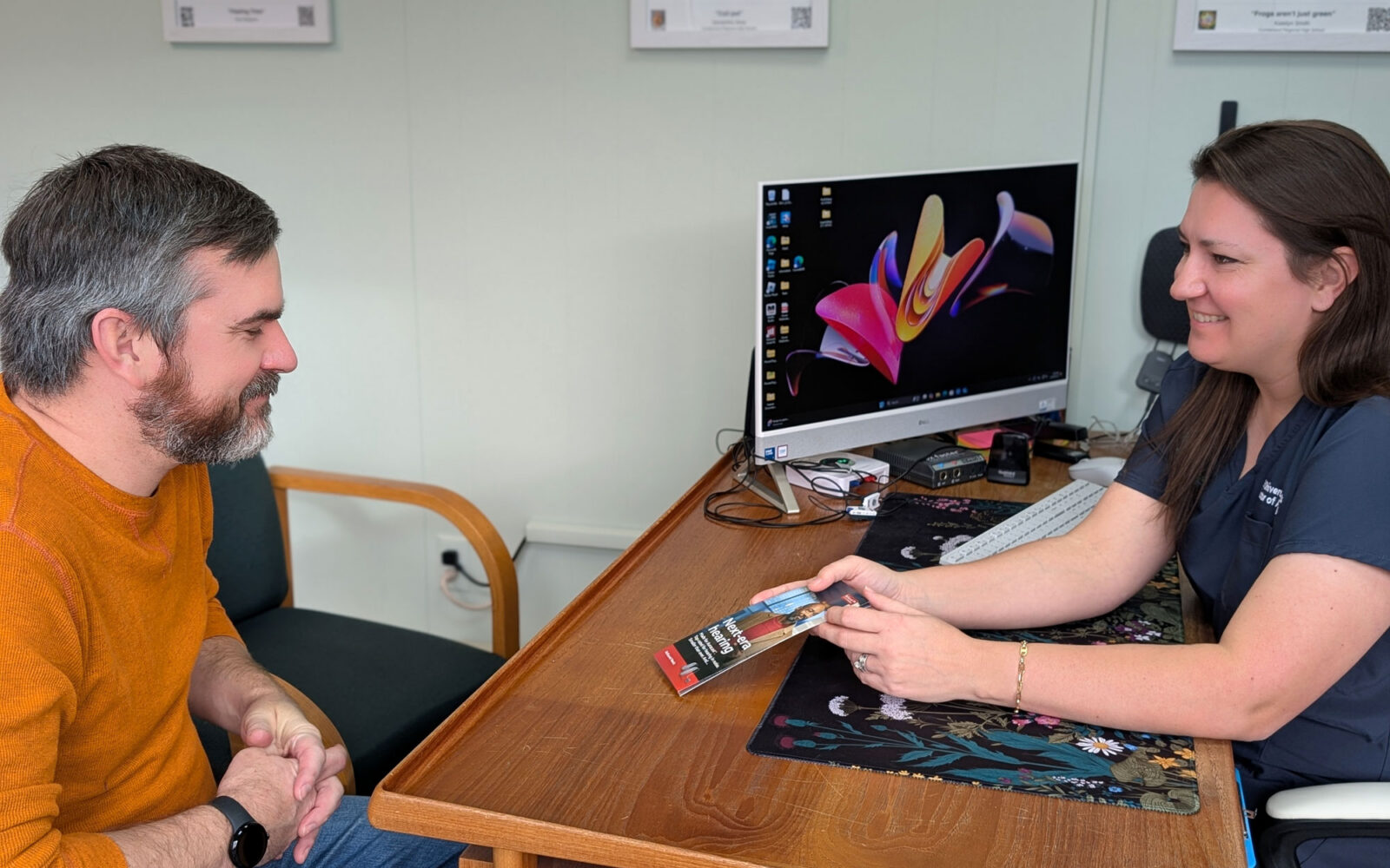Kelli Shivers Beswick Au D with patient during consultation handing flyer