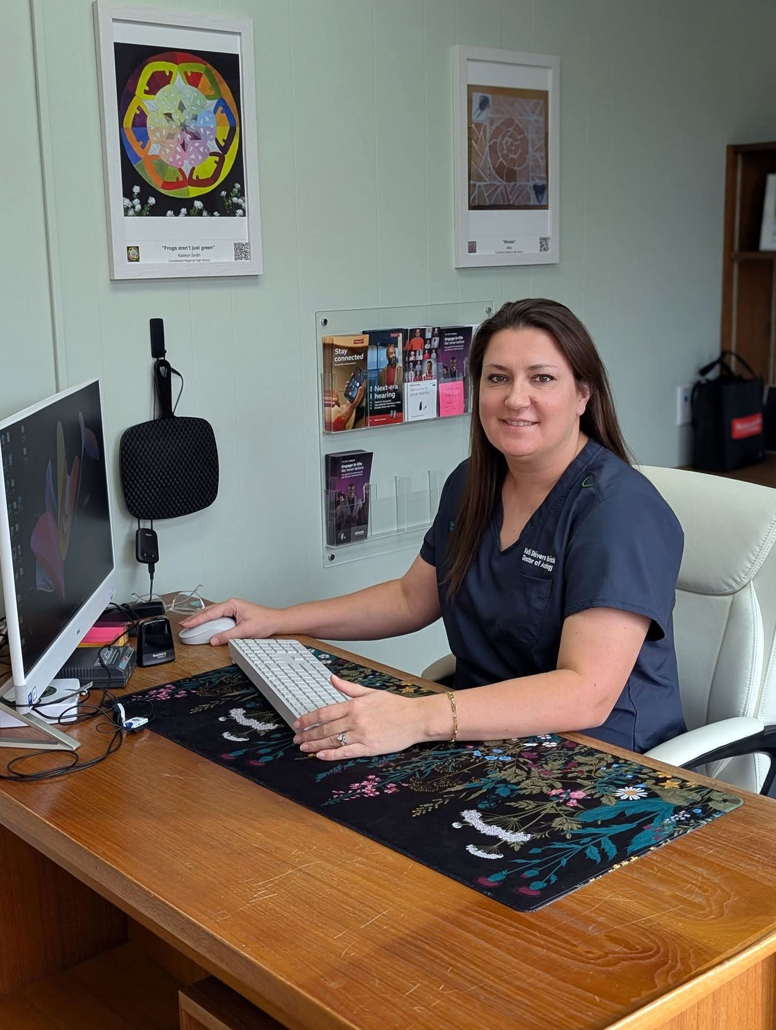 Kelli Shivers Beswick Au D at desk smiling
