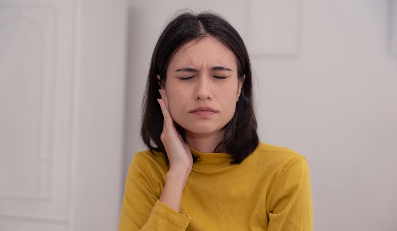 tinnitus patients with ear discomfort woman holding hand to ear in discomfort