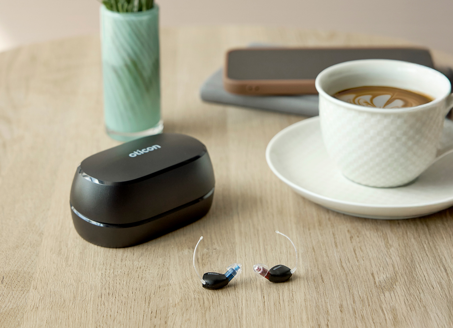 oticon zeal lifestyle hearing aids charging case by coffee cup