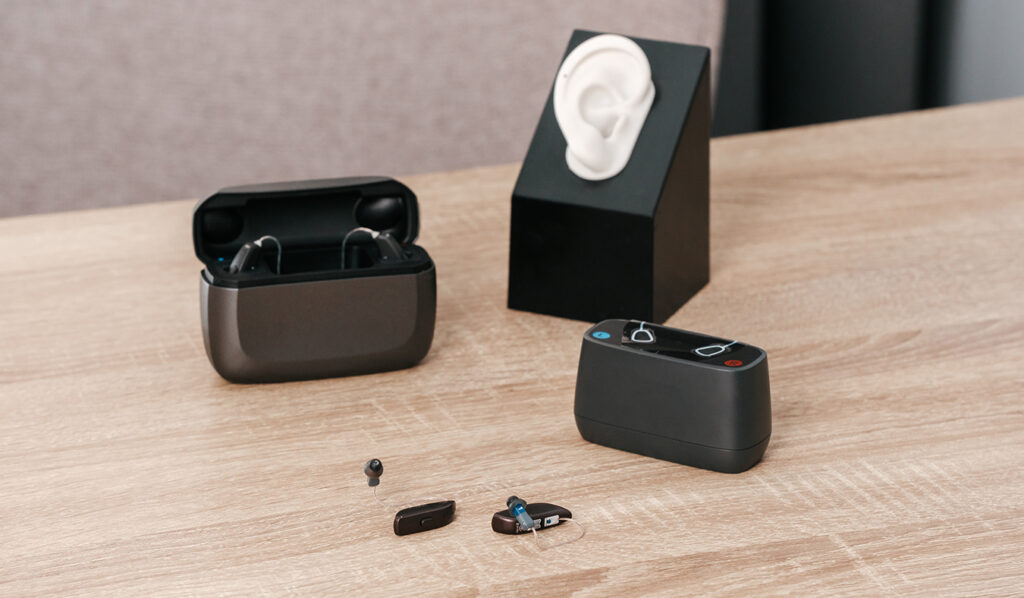 hearing aids devices only heraing aids on table with desktop charger and portable charging case