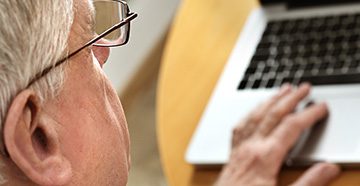 older-man-scrolling-laptop