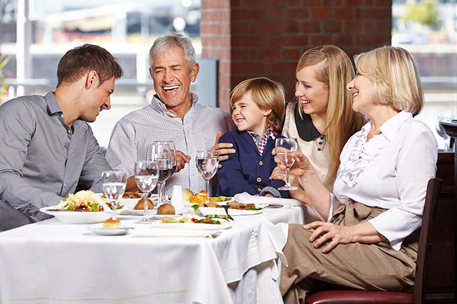 family-laughing-at-dinner-table