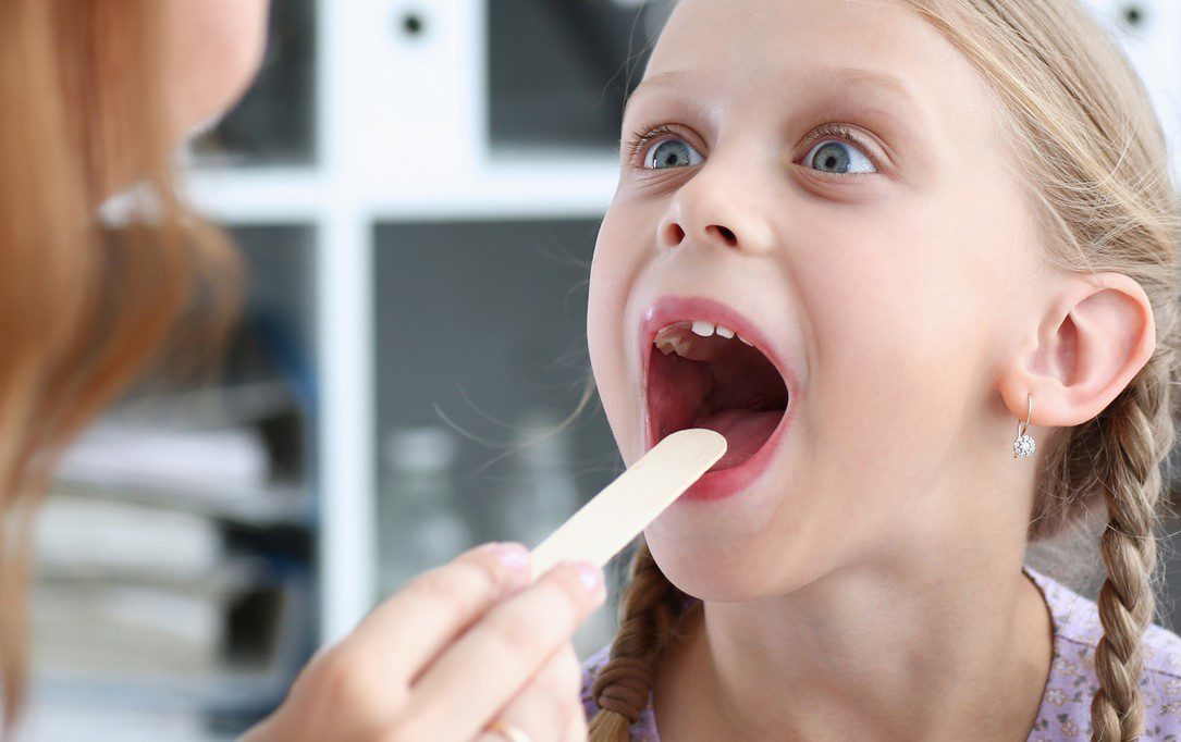 doctor examing child throat cropped