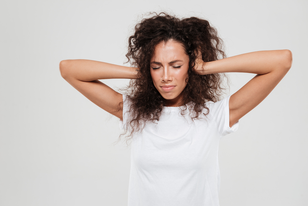 young woman with pretty hair has a nasty headache