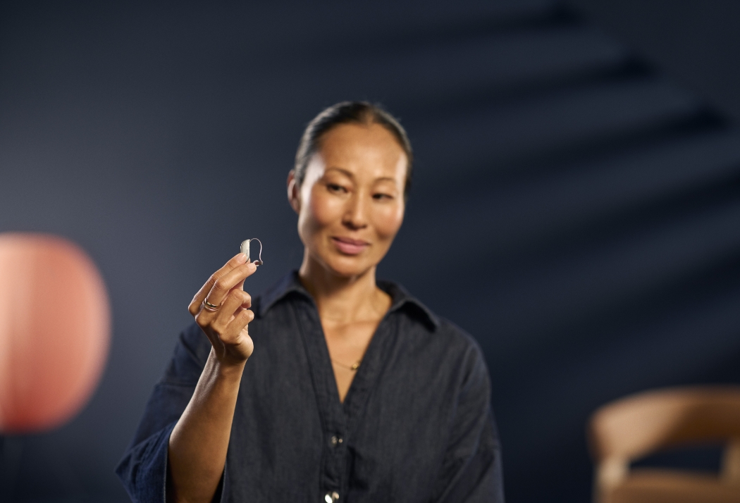ReSound Savi Woman holding hearing aid in hand