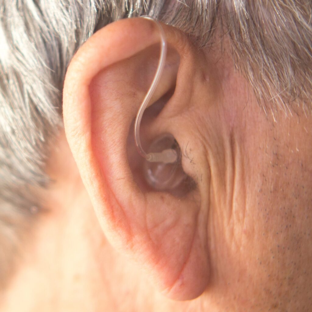 senior male closeup hearing aid