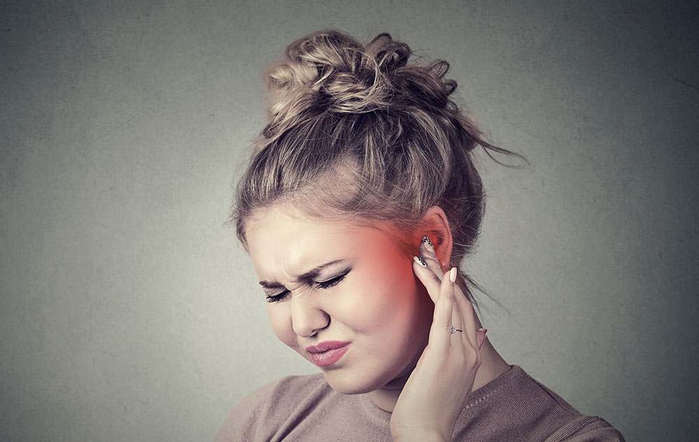 a woman experiencing slight ear discomfort 1
