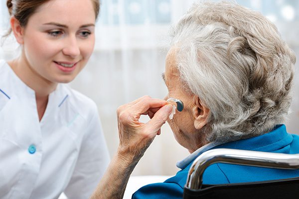 senior woman being fitted with new hearing aids