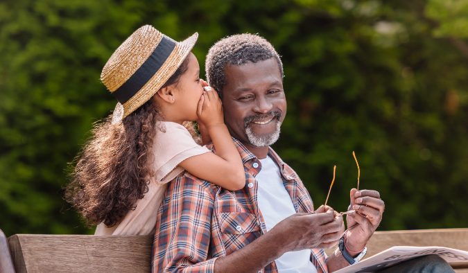 event image african american grandchild whispering to grandfather