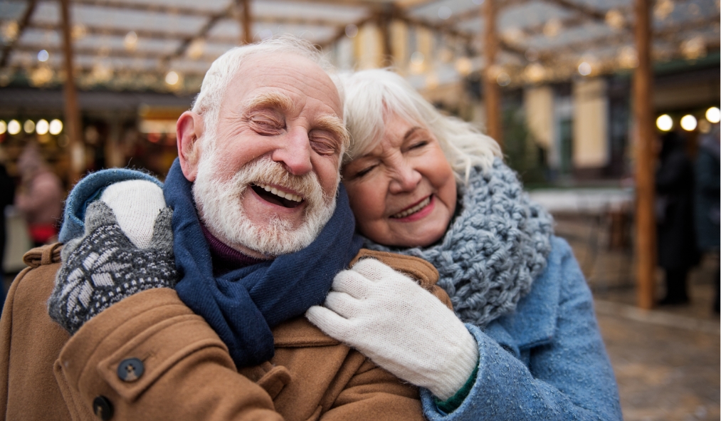 events winter mature couple hugging outside market