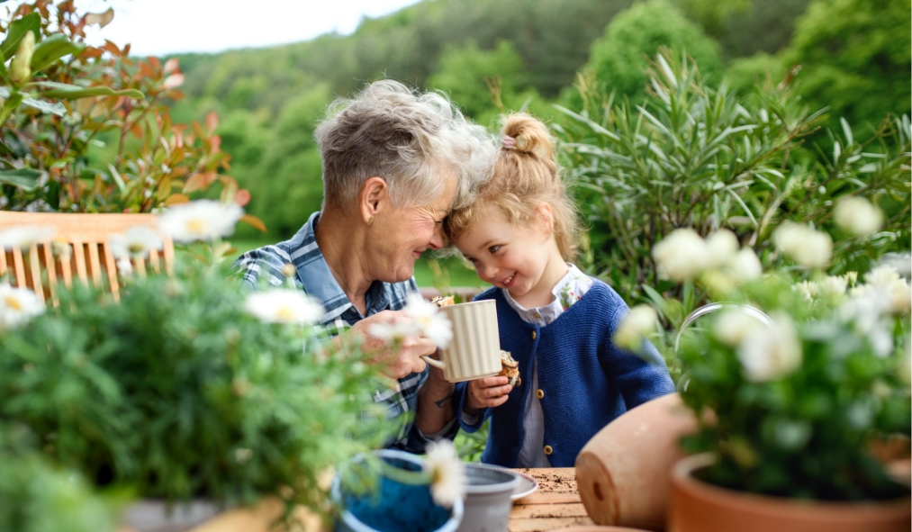spring grandmother planting flowers with granddaughter