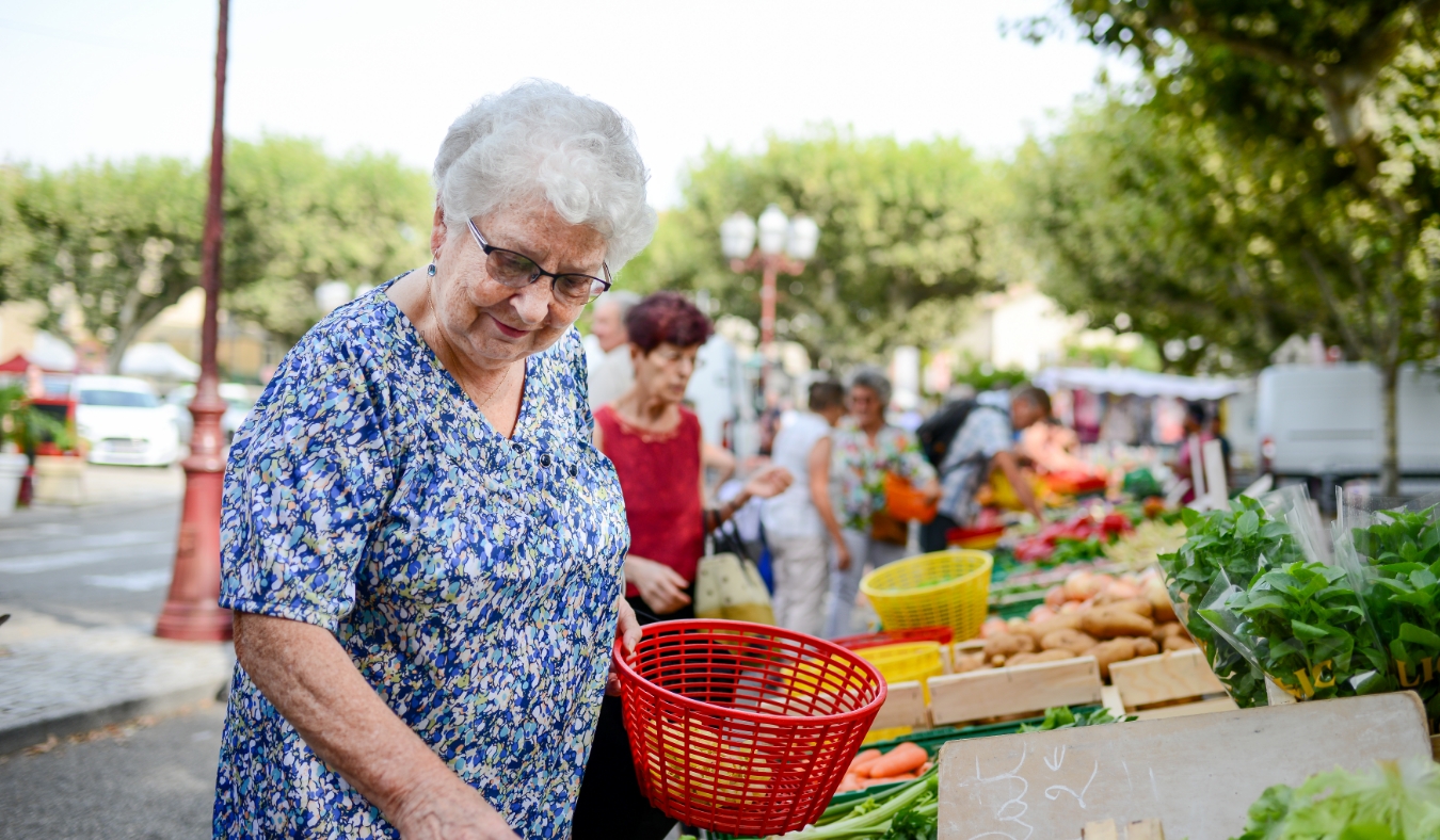 elderly senior woman buying fresh vegetables and fruits in farmer's market