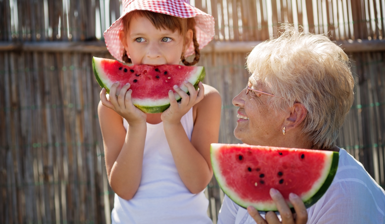 child and grandmother eating watermelon