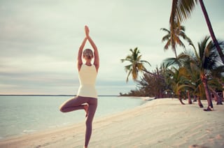 Ladying doing yoga on the beach