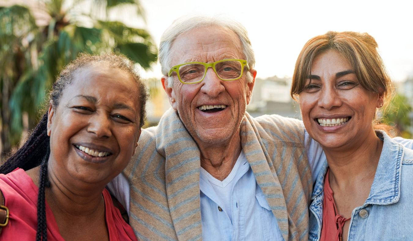 three senior friends outside smiling for camera