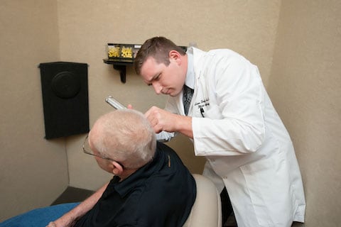 audiologist working on patient in his hearing clinic