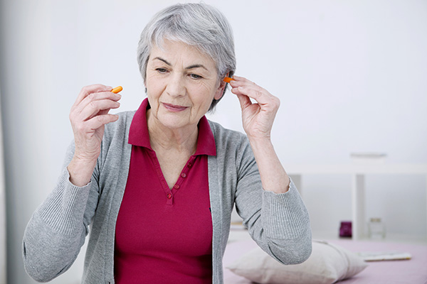 senior inserting hearing protection earplugs