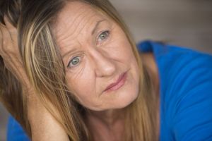a sad and morose looking woman staring into the camera with dead eyes