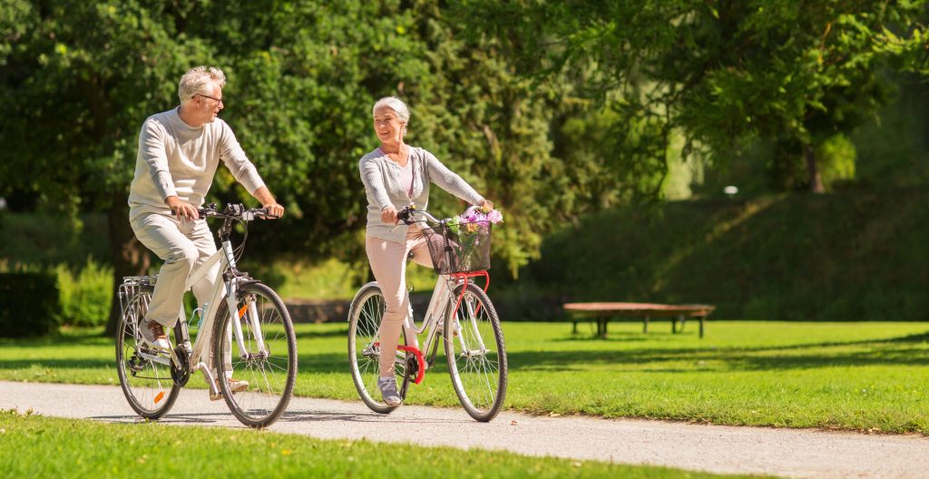 older couple riding bikes min older couple riding bikes min
