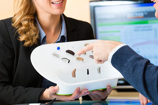 hand pointing to hearing aid devices