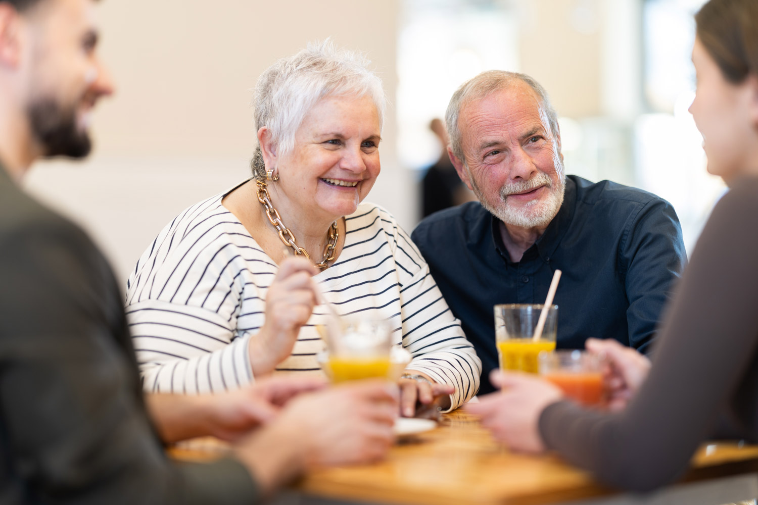 friendly family gathered at table to have meeting in restaurant