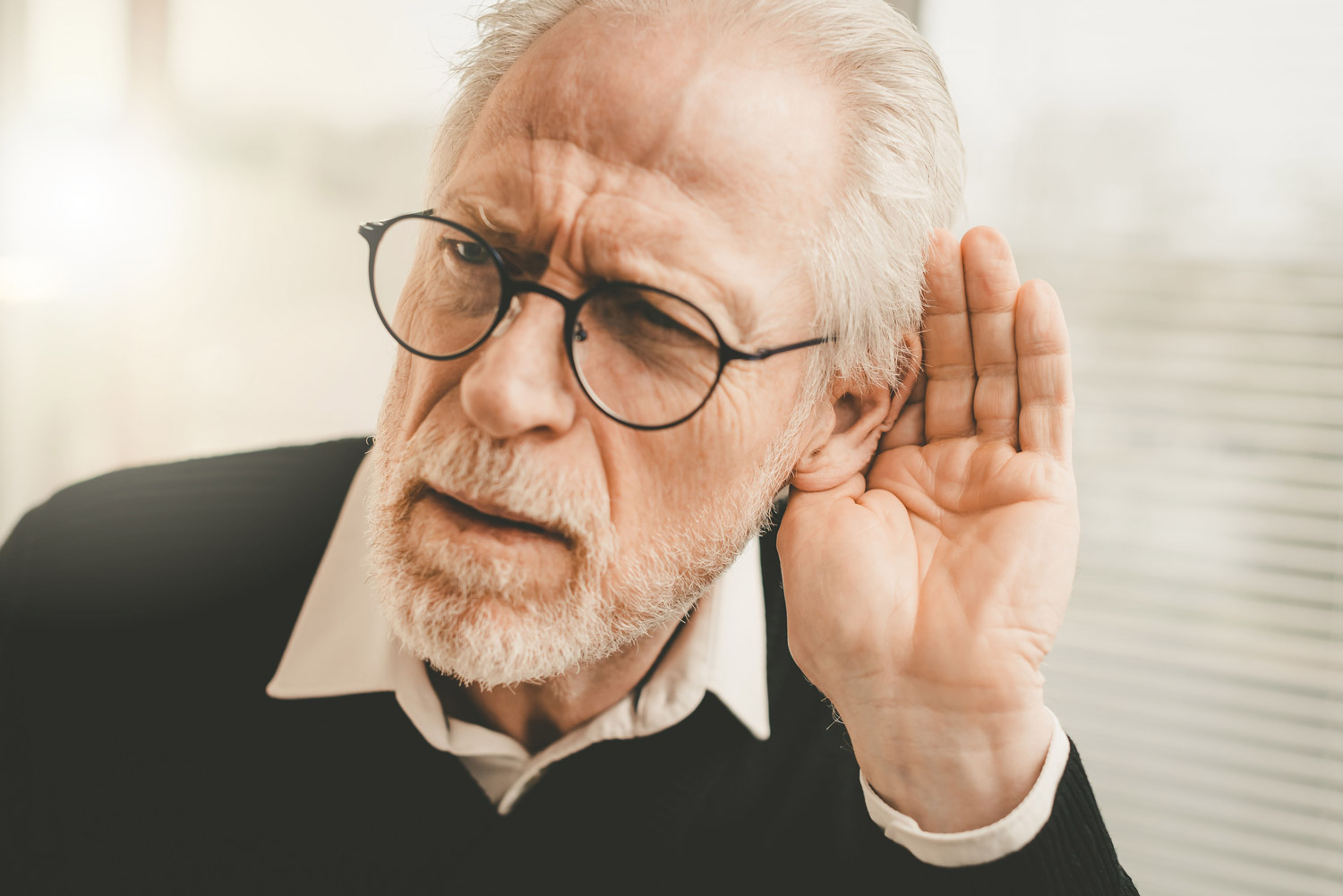 senior man having trouble listening
