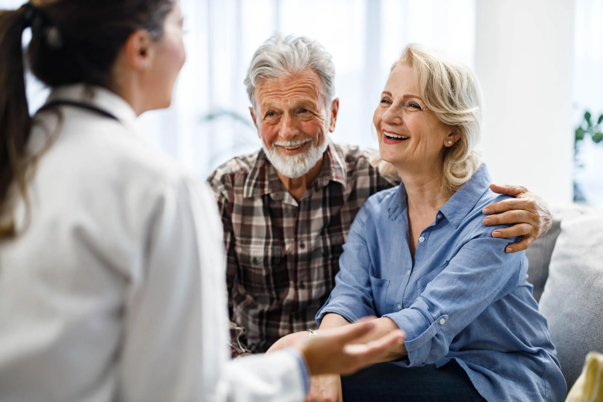 Happy mature couple talking to their doctor during visit