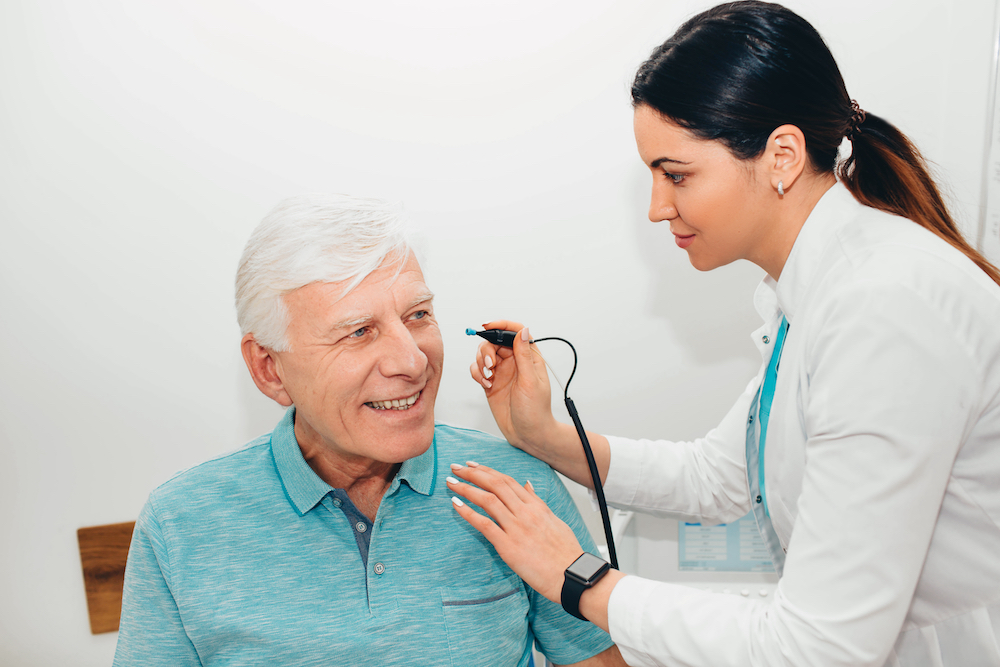 man discussing results of hearing evaluation with friendly audiologist